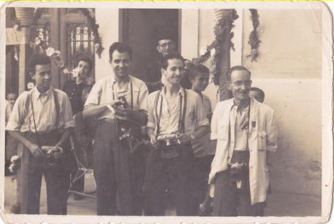 Año 1953. Cuatro maniseros, pioneros de la fotografía. Llevan al cuello la misma máquina de fotografiar alemana, “Leica”. De izquierda a derecha: D. Carlos Sanchis, D. Juan Satolaria, D. José Gadea y D. Juan Soler.