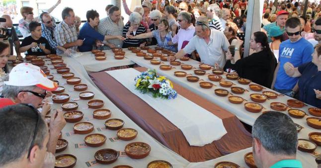 Decenas de personas participan en la degustación popular del arroz con leche en el festival. / LUCAS BLANCO